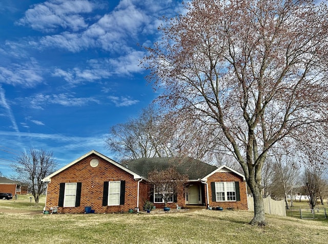 ranch-style home featuring brick siding and a front yard