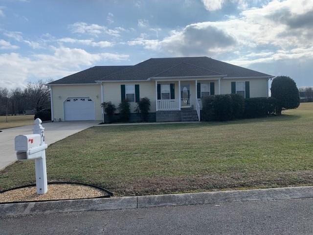 ranch-style house with a garage, a front yard, and covered porch