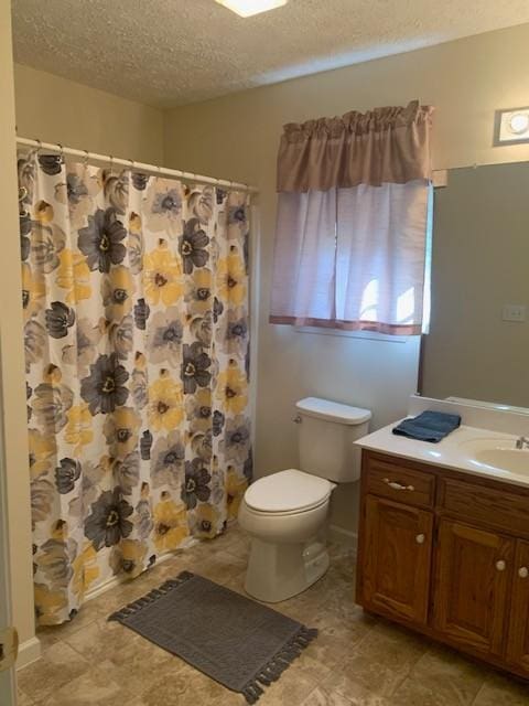 bathroom featuring vanity, curtained shower, a textured ceiling, and toilet