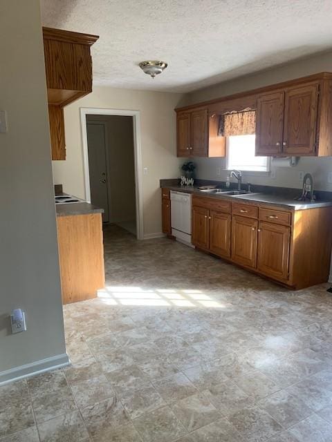 kitchen featuring sink, a textured ceiling, and white dishwasher