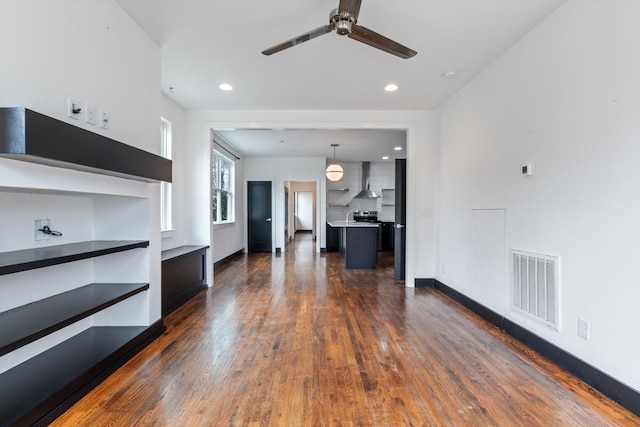 unfurnished living room with ceiling fan and dark hardwood / wood-style floors