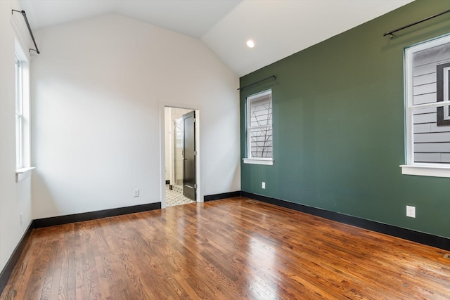 unfurnished bedroom with hardwood / wood-style flooring and vaulted ceiling