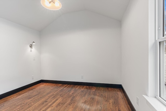 empty room with vaulted ceiling and dark hardwood / wood-style floors