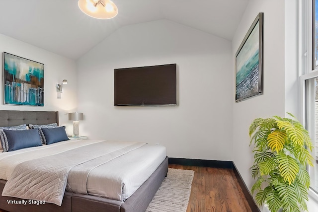 bedroom with lofted ceiling and dark hardwood / wood-style floors