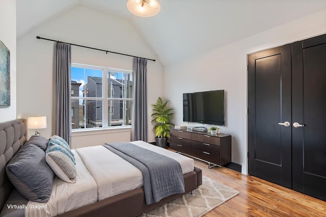 bedroom featuring lofted ceiling and light hardwood / wood-style floors