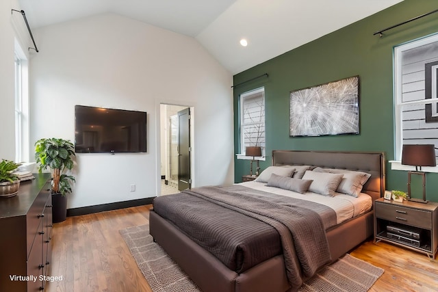 bedroom featuring lofted ceiling and light wood-type flooring