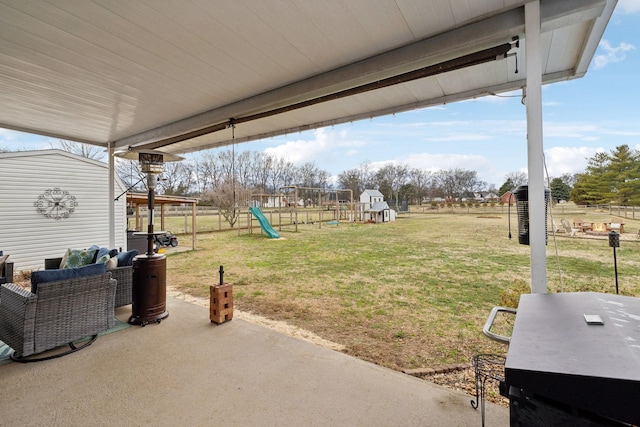 view of yard featuring a shed, an outdoor living space, a patio area, and a playground