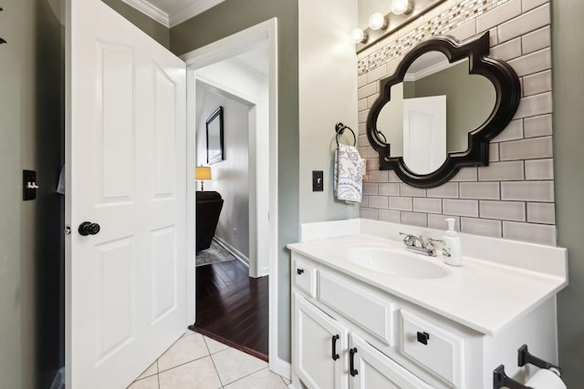 bathroom featuring tile patterned flooring, vanity, and crown molding