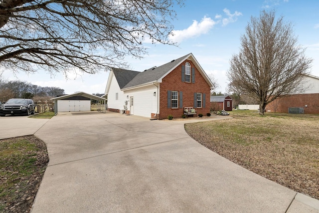 view of side of property with a shed, a yard, and a garage