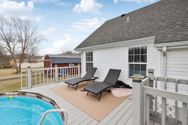 deck featuring a fenced in pool and a storage unit