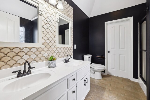 bathroom featuring lofted ceiling, tile patterned floors, toilet, and vanity