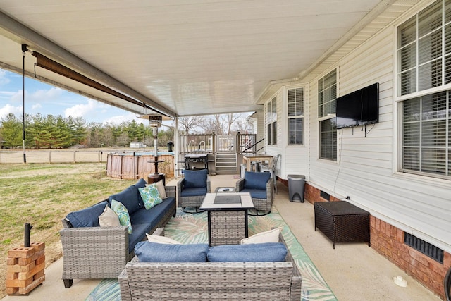 view of patio with an outdoor living space with a fire pit