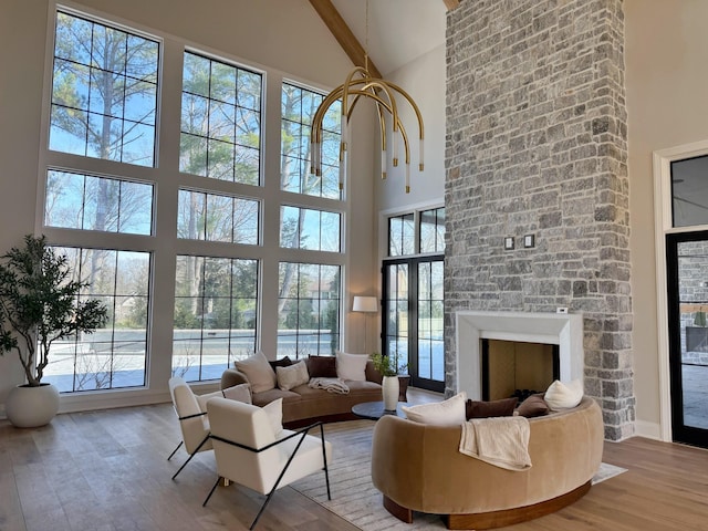 living room featuring a large fireplace, light hardwood / wood-style flooring, and a wealth of natural light