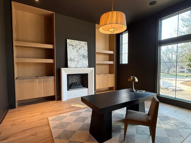 office area with built in features and light wood-type flooring