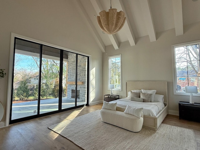 bedroom featuring beamed ceiling, high vaulted ceiling, access to outside, and light wood-type flooring