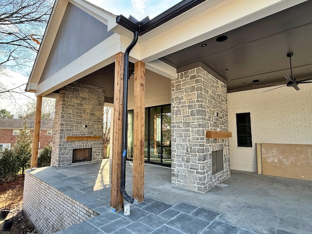 view of patio with ceiling fan and an outdoor stone fireplace