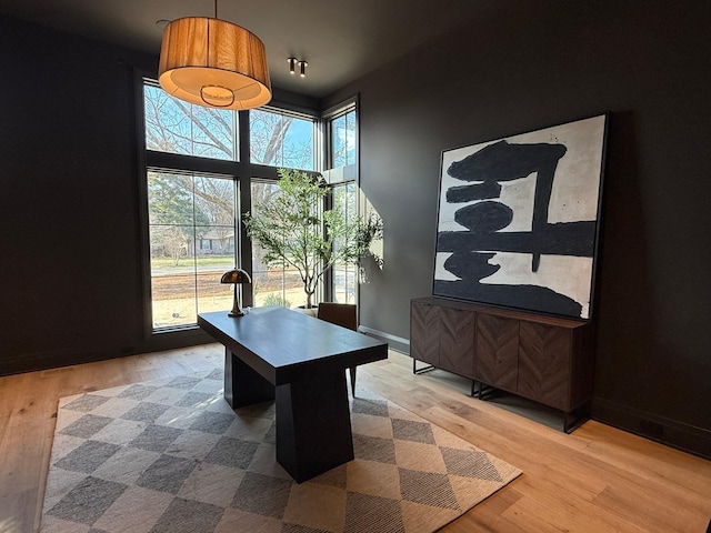 office space featuring wood-type flooring and a towering ceiling