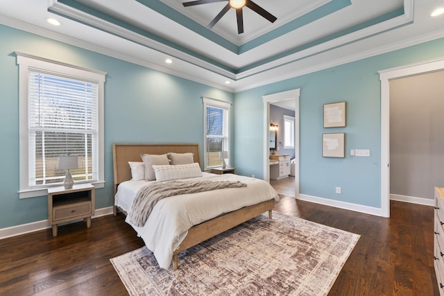 bedroom featuring dark wood-style floors, baseboards, a tray ceiling, and ornamental molding