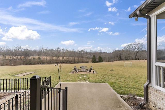 view of yard featuring a patio area, a rural view, a fire pit, and fence
