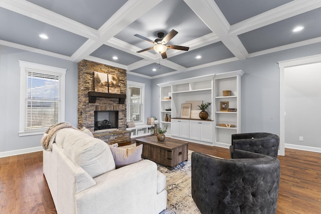 living area featuring beam ceiling, coffered ceiling, dark wood finished floors, a fireplace, and baseboards