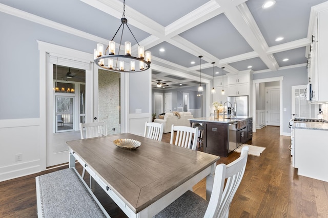 dining area featuring coffered ceiling, dark wood finished floors, ceiling fan, beamed ceiling, and a decorative wall