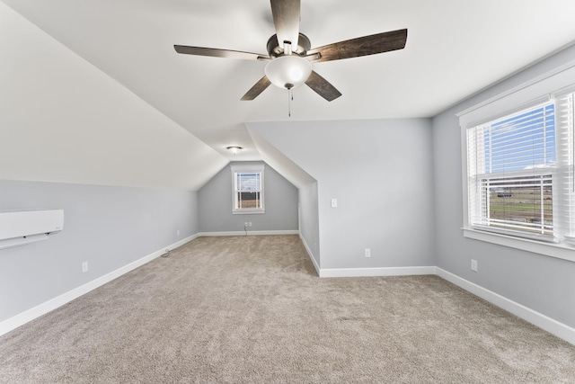 additional living space with baseboards, light carpet, lofted ceiling, and a healthy amount of sunlight
