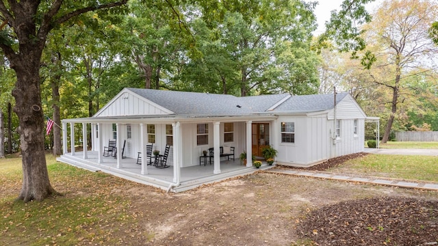 rear view of property featuring covered porch