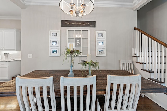 dining area with hardwood / wood-style flooring, ornamental molding, and a chandelier