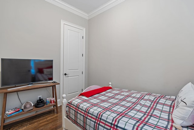 bedroom with crown molding and dark hardwood / wood-style floors