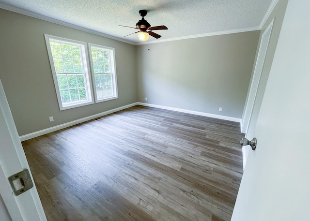 unfurnished room featuring baseboards, a textured ceiling, wood finished floors, and crown molding