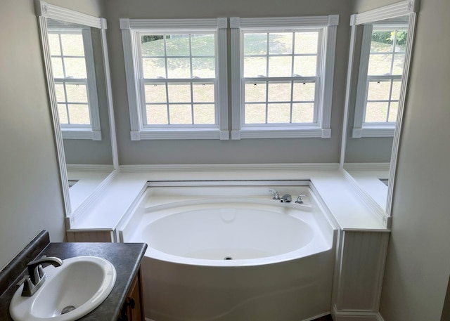 bathroom with vanity and a garden tub