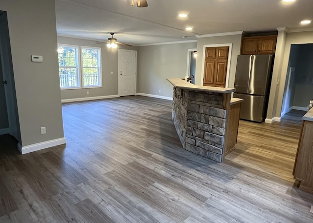 kitchen featuring light countertops, dark wood-style flooring, freestanding refrigerator, and ornamental molding