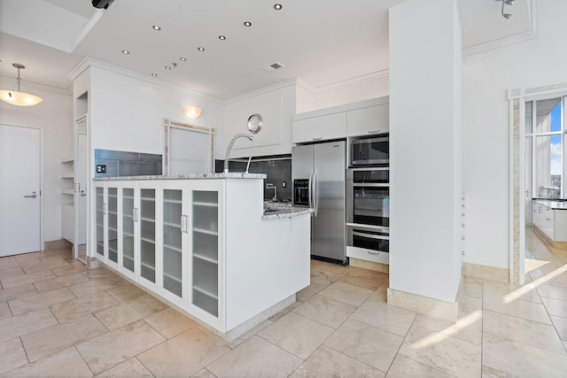 kitchen with white cabinetry, light stone counters, ornamental molding, stainless steel appliances, and backsplash