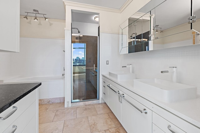 bathroom featuring vanity, tile walls, backsplash, and a shower with shower door