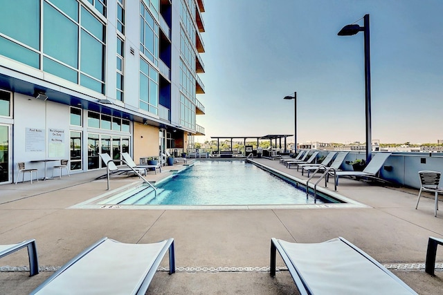 pool at dusk with a patio