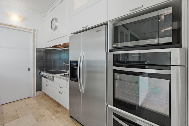 kitchen with white cabinetry, appliances with stainless steel finishes, crown molding, and decorative backsplash