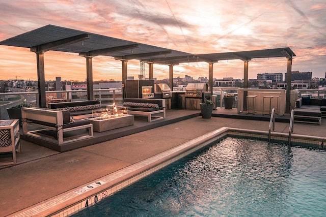 pool at dusk featuring a patio and an outdoor fire pit