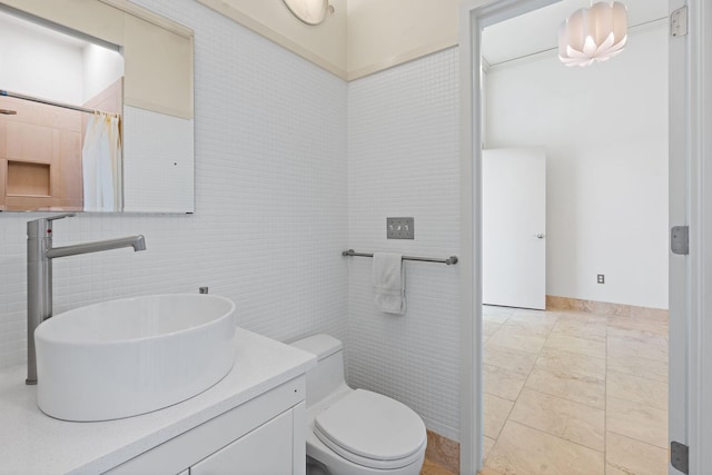 bathroom with vanity, tile walls, walk in shower, and toilet