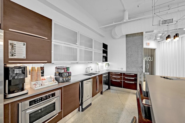 kitchen featuring stainless steel appliances, sink, and hanging light fixtures