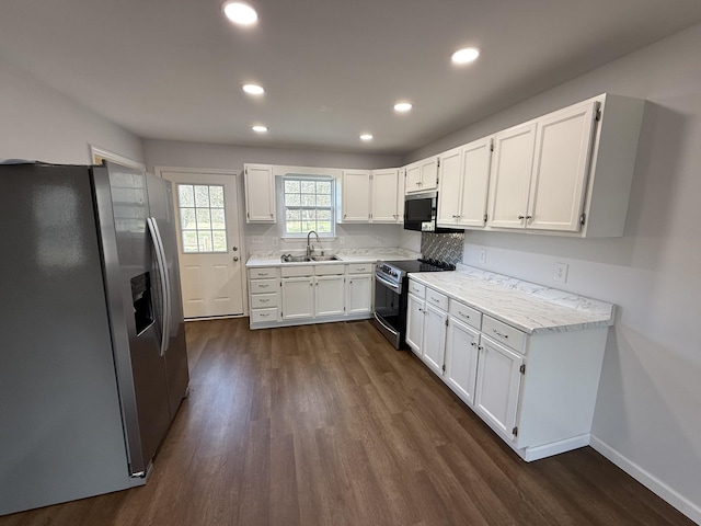 kitchen featuring dark hardwood / wood-style flooring, sink, stainless steel appliances, and white cabinets