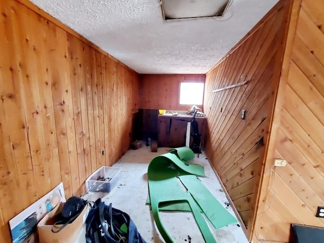 laundry area with wooden walls and a textured ceiling