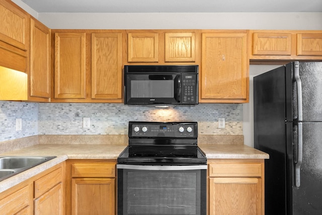 kitchen featuring tasteful backsplash, sink, and black appliances