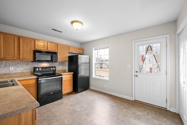 kitchen featuring backsplash, plenty of natural light, and black appliances