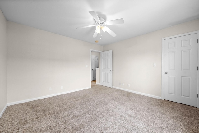 carpeted spare room featuring ceiling fan