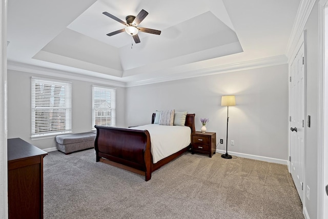 bedroom with light carpet, a tray ceiling, ornamental molding, and ceiling fan