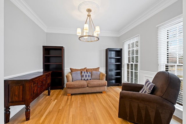 living room with crown molding, an inviting chandelier, and light wood-type flooring