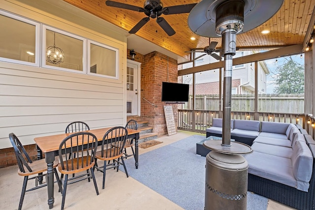 sunroom with a healthy amount of sunlight, ceiling fan with notable chandelier, and wooden ceiling