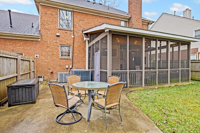 rear view of house featuring a patio, a sunroom, and central AC unit