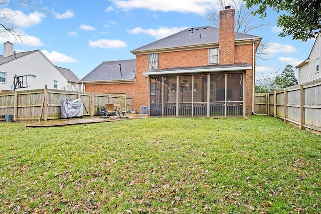 rear view of house with a yard, a patio area, and a sunroom