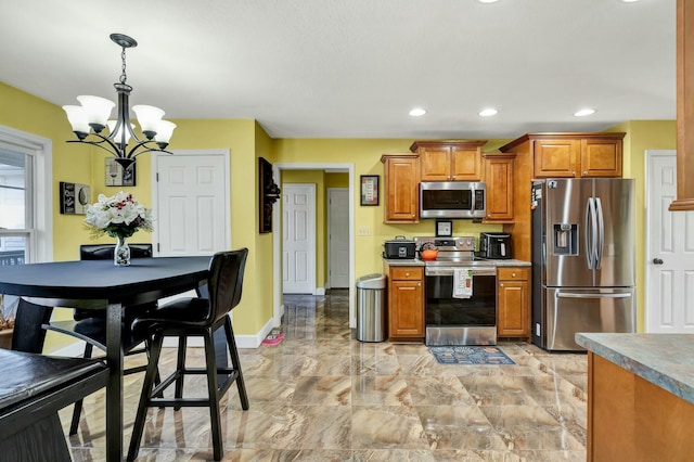 kitchen with appliances with stainless steel finishes, pendant lighting, and a notable chandelier